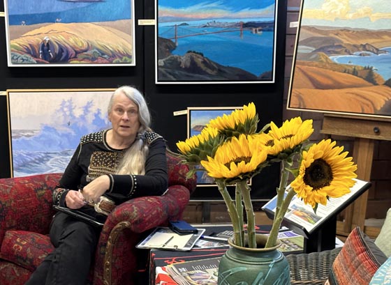 Linda Sorensen, seated in her studio with sunflowers